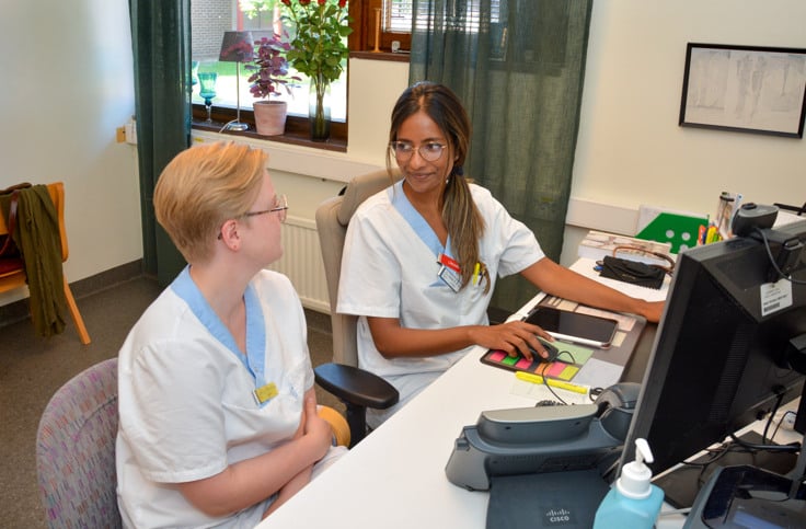 Shanie och handledaren Jenny Hedgren Rönnlund vid ett skrivbord.