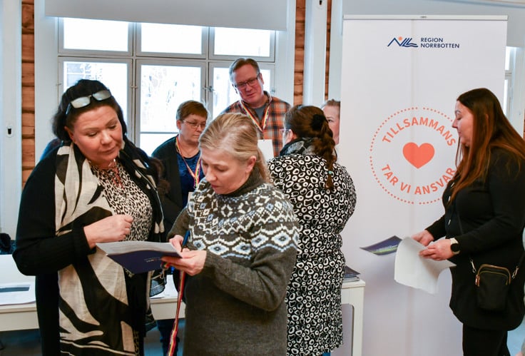 Två kvinnor läser informationsmaterial .