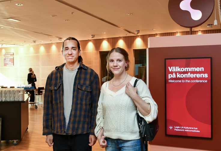 Två personer tittar in i kameran.