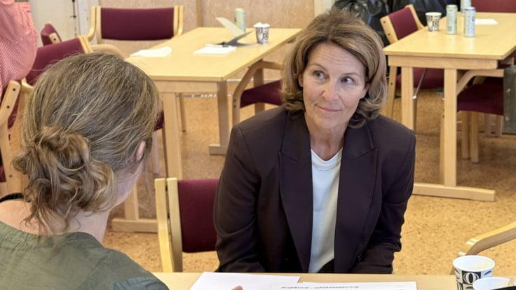 Kvinnor samtalar intill ett bord.