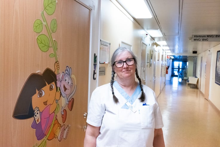 En kvinna som står i en sjukhuskorridor.