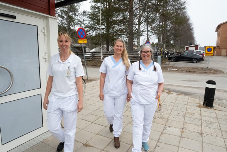 En grupp sjuksköterskor som går längs en trottoar.