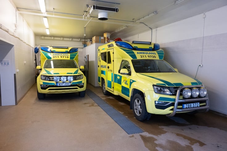 Två ambulanser som står parkerade i ett garage.