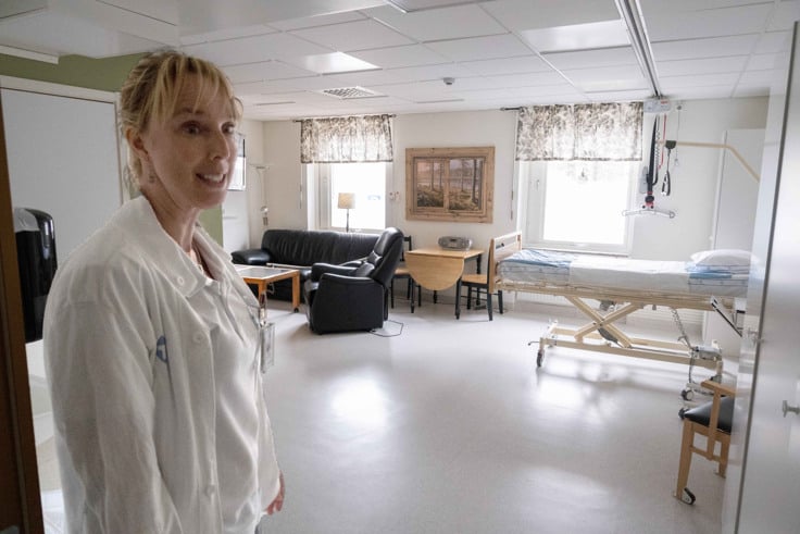 En arbetsklädd kvinna som står i ett rum.