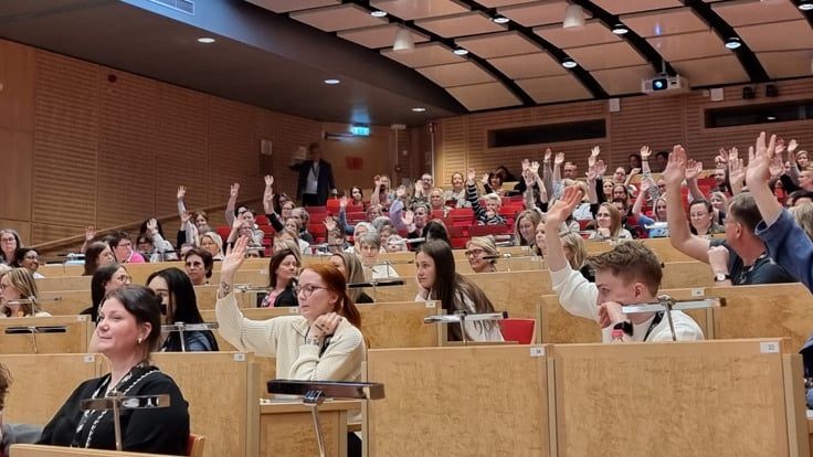 En grupp människor som sitter i en föreläsningssal.