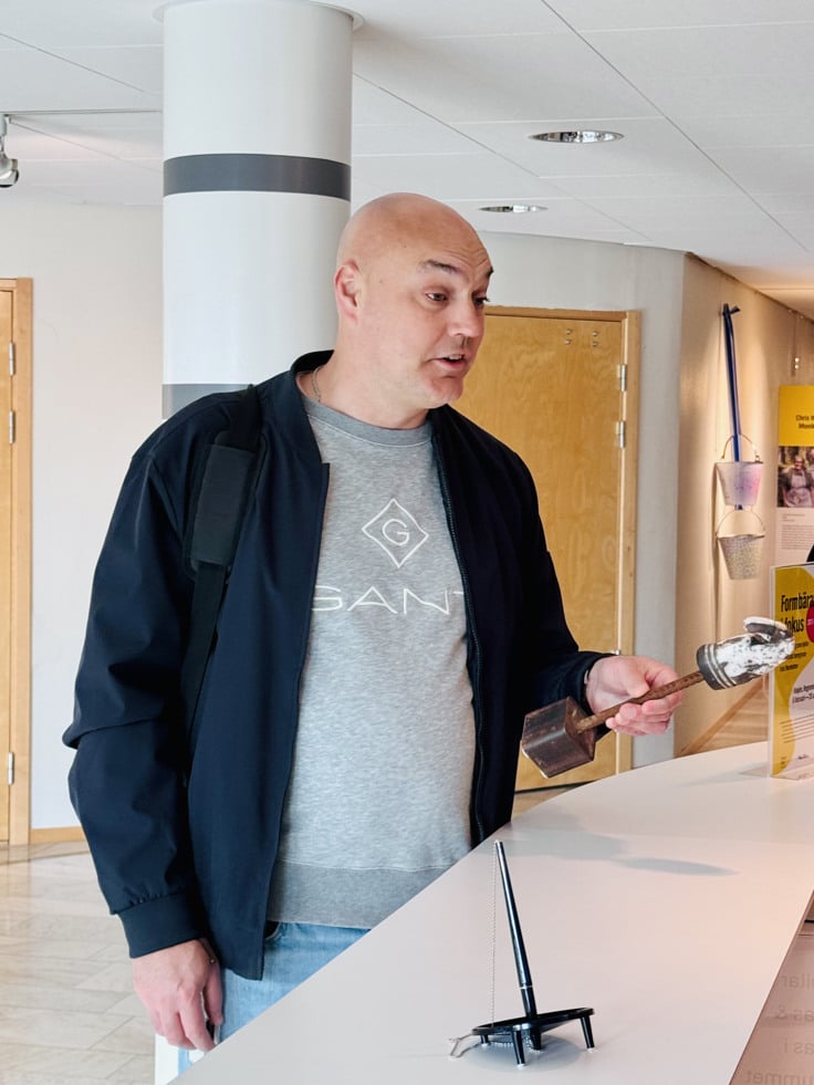 Niklas Larsson står med en skulptur vid receptionen i Regionhuset
