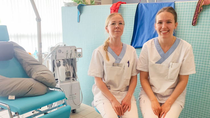 Sandra Greus och Anna Näsström, i vita arbetskläder, tittar in i kameran.