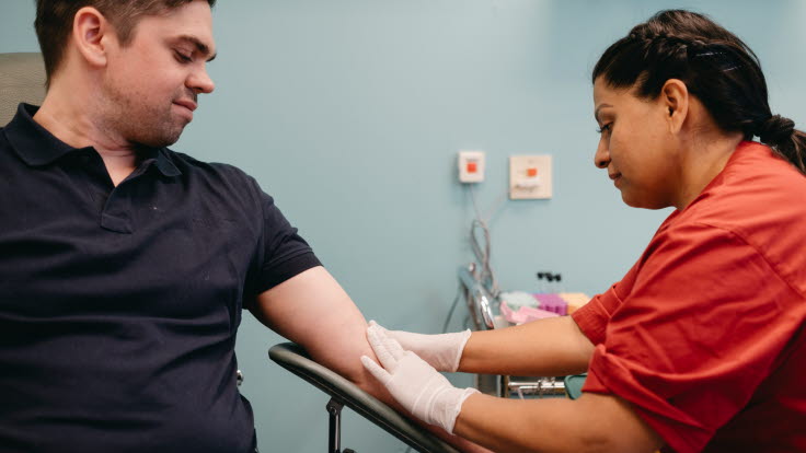 En sjuksköterska tar blodprov på en man.