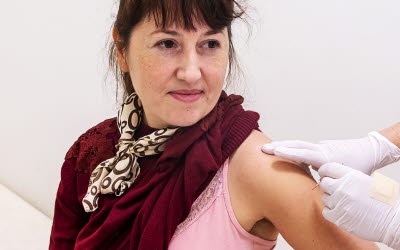 Person som blir vaccinerad mot covid-19 av vårdpersonal