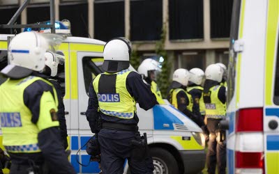 Poliser från insatsstyrka vid polisbilar, foto